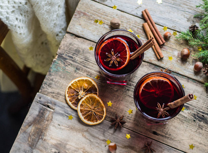 传统的冬季酒精饮料美酒。木桌上的热葡萄酒, 杯中的水果和香料