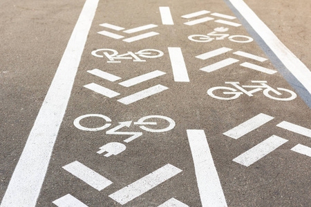 沥青路面有自行车和电动运输车道。循环和零排放车辆白色标志在地板上。城市公园绿色能源运输游憩区