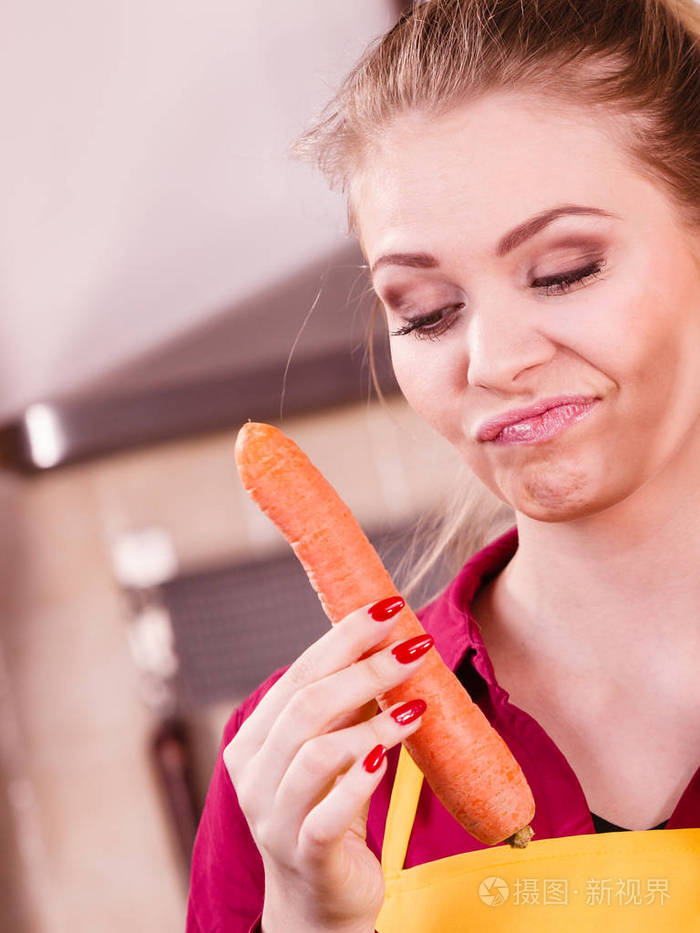 女人不喜欢蔬菜。女性坚持胡萝卜有鬼脸表情