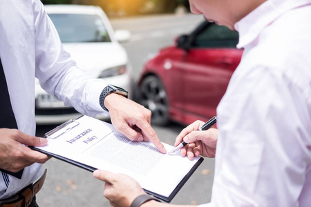保险代理人检查车后事故索赔被评估和处理的时候写在剪贴板上