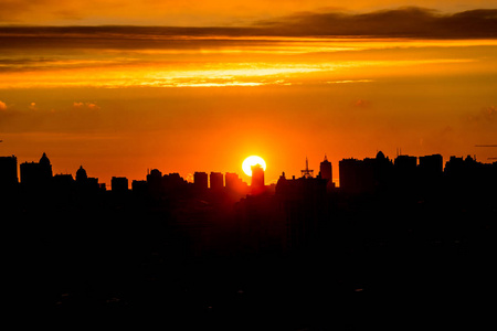 朝阳升起太阳升起在城市在温暖的日落与云彩照片