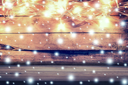 圣诞灯，木背景上的木桌上的雪