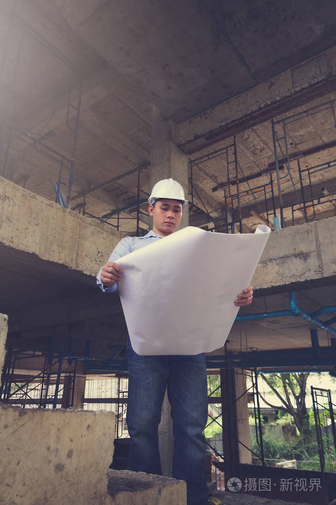 与蓝图,老式效果在建筑工地工作的工程师建筑师