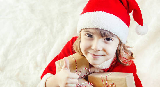 儿童在白色背景下拥有圣诞装饰和礼物。选择性对焦。快乐