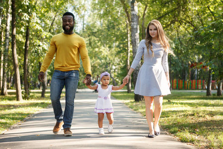 非洲裔美国人的父亲和一个带着女儿散步的白人母亲