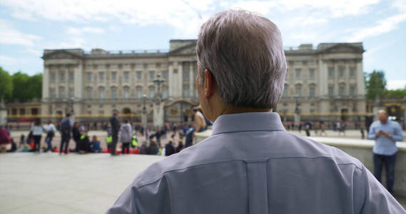 英国白人在伦敦度假时, 年迈的白人男子在白金汉宫四处寻找照片