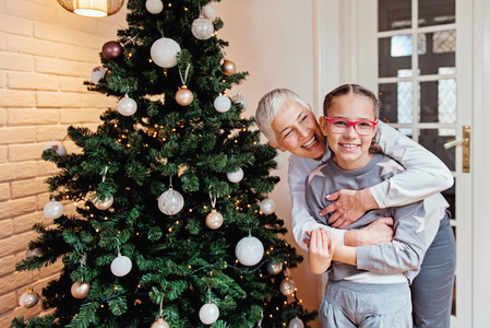 祖母和孙女装饰一棵圣诞树图片
