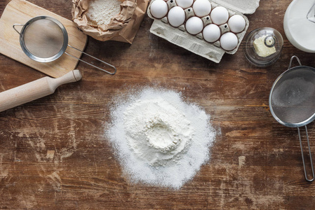 木桌上的白面粉和烘焙原料的顶视图