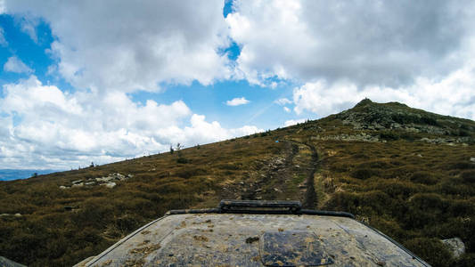 乘汽车旅行在乌克兰喀尔巴阡山脉。兜帽车和山景。越野