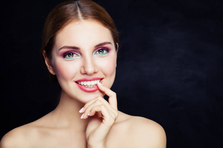 完美的年轻女子化妆和可爱的微笑在黑色背景照片