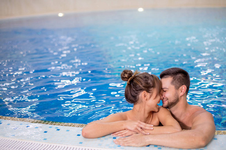 年轻夫妇在游泳池里玩得很开心. 积极的生活方式概念