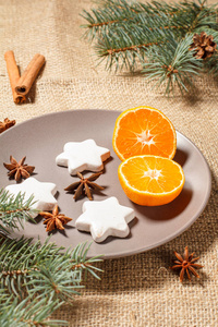姜饼饼干在盘子上的星形与肉桂, 八角和天然冷杉树枝与圆锥在麻布。色彩调理效果