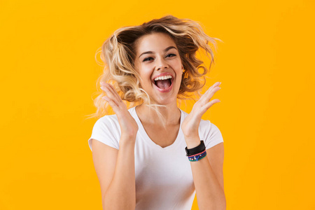 照片惊讶的妇女在基本的衣服尖叫和笑被隔绝在黄色背景照片
