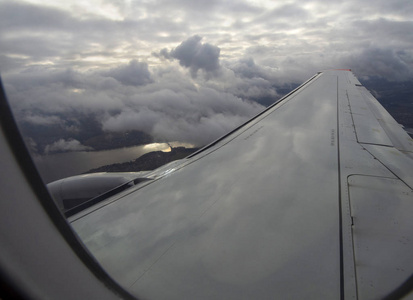 在一个多云的秋日, 飞机在河上的云端和俄罗斯莫斯科市上空的森林下飞行