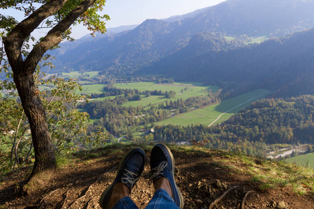 从山顶上可以欣赏到布莱德的环境。脚在运动鞋里。休眠概念