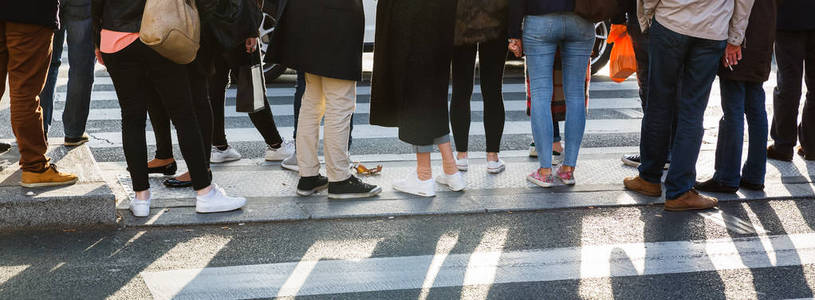 在人行横道上横穿马路的人群的腿图片照片