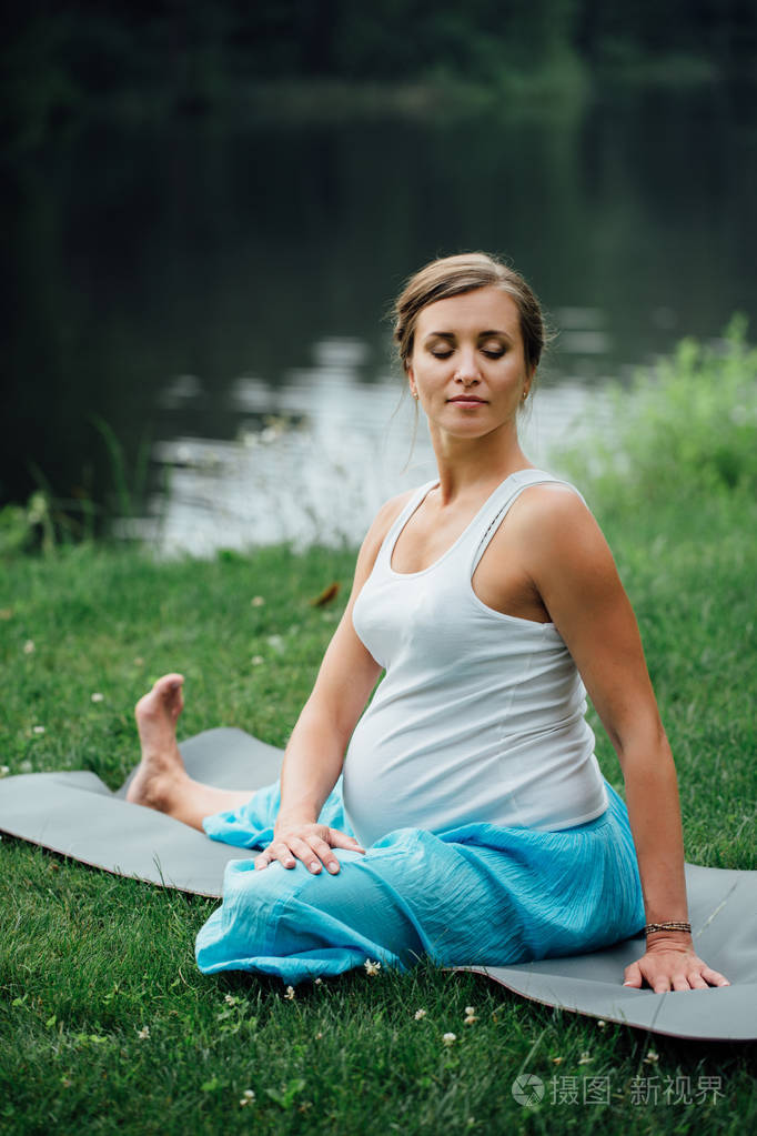 在荷花的立场上森林背景的孕妇瑜伽.在公园草地垫, 户外, 健康女人
