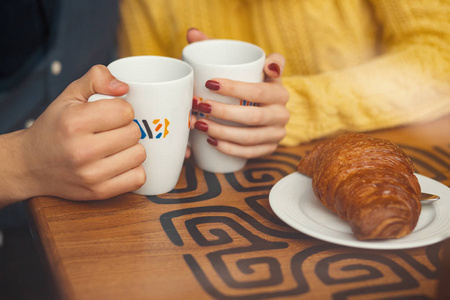 年轻夫妇在约会时手和杯子与咖啡。选择性对焦