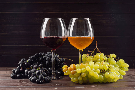 木桌上的酒杯和葡萄束