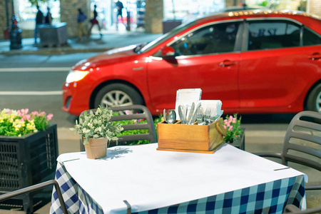 户外餐厅桌与红色汽车停在前面