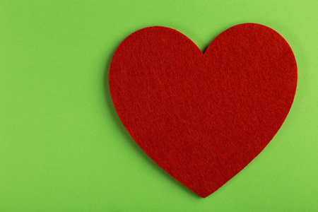 红色的心在明亮的绿色背景。情人节。复制空间