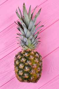 成熟的菠萝粉红色的木材, 顶部的看法。健康营养的菠萝果, 躺在彩色木制背景上