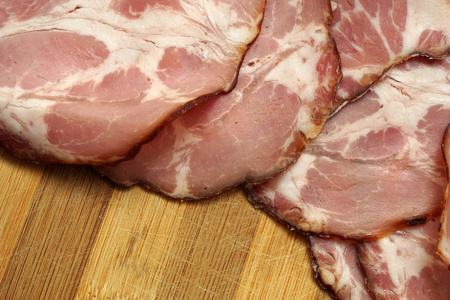 猪肉火腿切片上木制的背景。特写