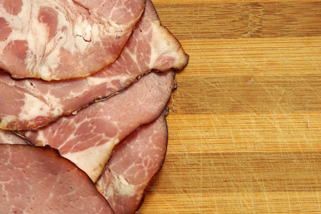 猪肉火腿切片上木制的背景。特写