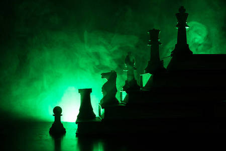 业务层次结构。战略概念与棋片断。国际象棋站在一金字塔的书籍与国王在顶部。暗雾背景与色调的光。复制空间