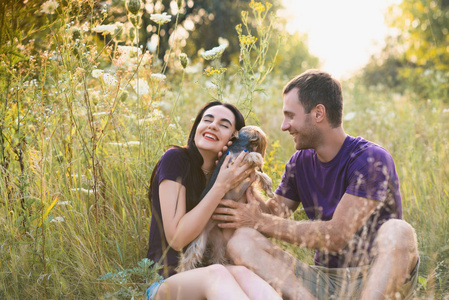 年轻幸福的夫妇和他们的狗一起拍照