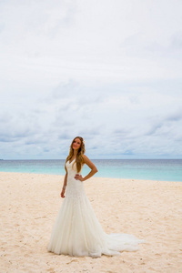 美丽的新娘，独自站在海边的热带海滩