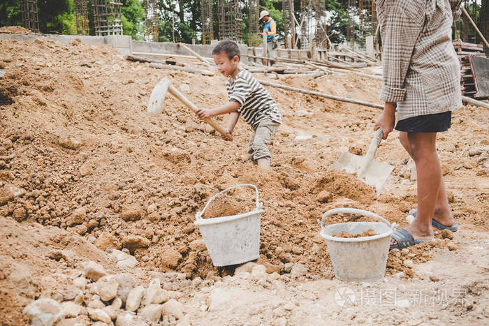 小男孩劳动在商业建筑结构中挖土, 世界禁止童工日概念
