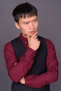 灰色背景下的中国青年商人肖像