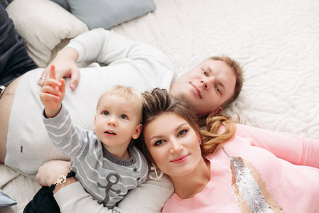肖像从上面的有吸引力的妻子和丈夫与儿子躺在床上