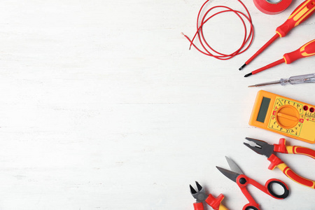 剪切钳和螺丝起子平面平面构图与电工的工具和空间为文本在木制背景