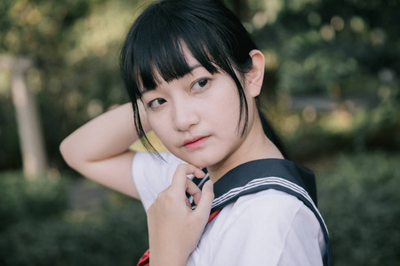 亚洲日本学校女孩服装的肖像看公园户外电影复古风格