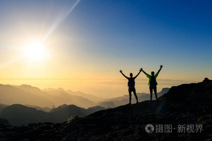 夫妇徒步旅行者在山上的成功和信任, 完成与手臂伸出.