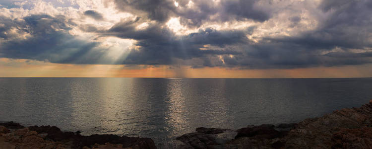 太阳的光束通过海面阴沉的天空