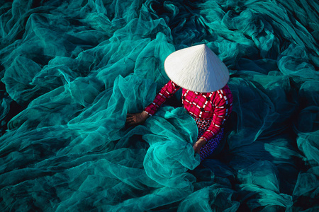 技能孤独越南妇女坐维修渔网照片