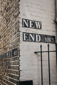 街道名称标志在建筑物的一侧在新的末端和斯特雷特利的地方, 汉普斯特德, 伦敦, 英国