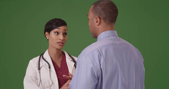 一名黑人医生在绿屏上为一名非洲裔美国人患者提供建议