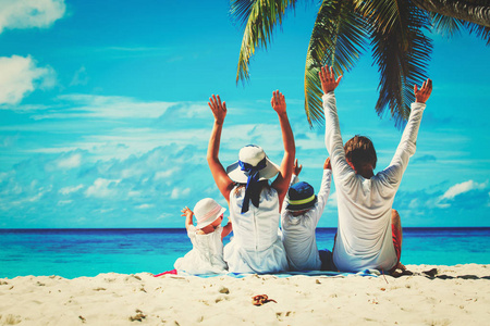 幸福的家庭，有两个孩子在沙滩上举起手来