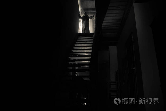 恐怖幽灵剪影站在城堡楼梯到地下室.鬼地牢石楼梯在老城堡与光.