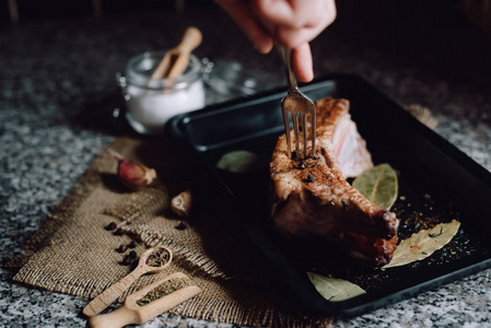 在黑暗背景的金属盒子里放上生肉。煮烤肉