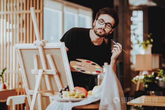 以工作为中心的木偶画画画笔画的年轻白种人的肖像.自由艺术家的概念