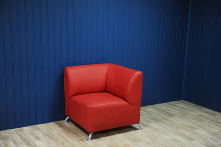 红色的皮革扶手椅，背景为蓝色的墙壁。纹理的设计