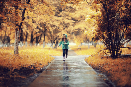 在秋天的公园跑步的女孩