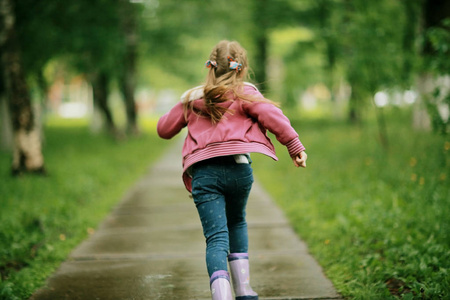 儿童风衣在秋天的公园跑步的女孩照片