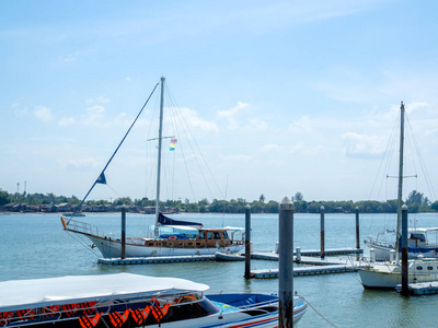 豪华游艇停靠在海港。在泰国克拉比, 在阳光明媚的日子里, 现代摩托艇在海上停车, 有渔民村和蓝天背景