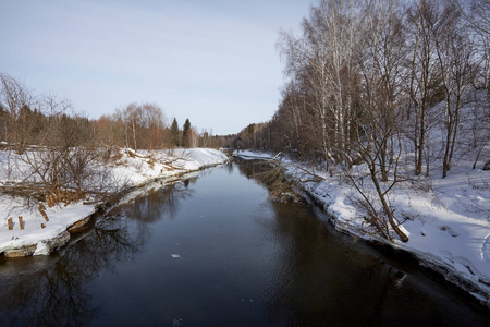 美丽的冬季景观与河流和雪。阳光寒冷的一天